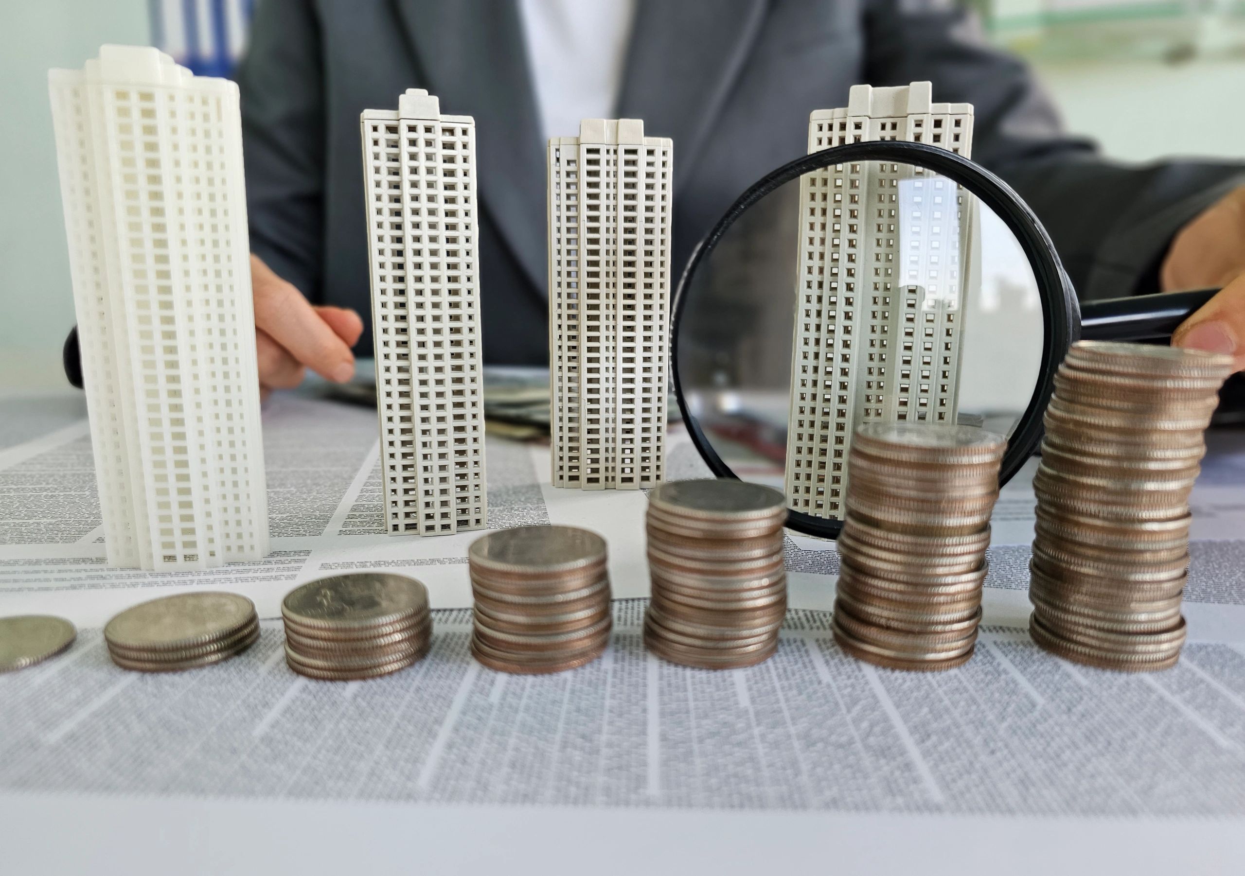 Sculpted buildings and coins symbolize real estate investment